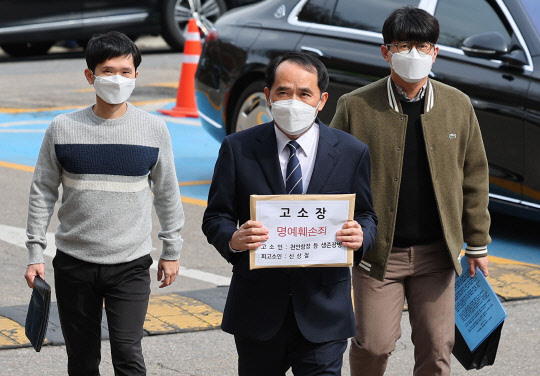최원일(가운데) 전 천안함 함장이 지난 3월 31일 오후 고소장을 들고 서울 서초경찰서로 향하고 있다. 이날 최 전 함장과 천안함 생존자 전우회는 천안함 사건에 대한 음모론을 제기한 신상철 전 민군합동조사단 민간위원을 명예훼손 혐의로 고소했다. <연합뉴스>